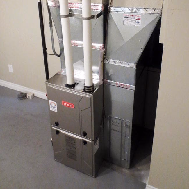 Newly installed Bryant gas furnace with two PVC flue pipes